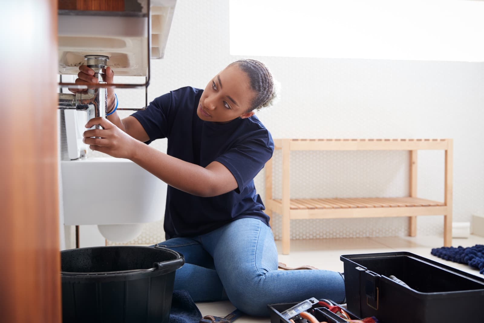 A plumbing professional working on a sink
